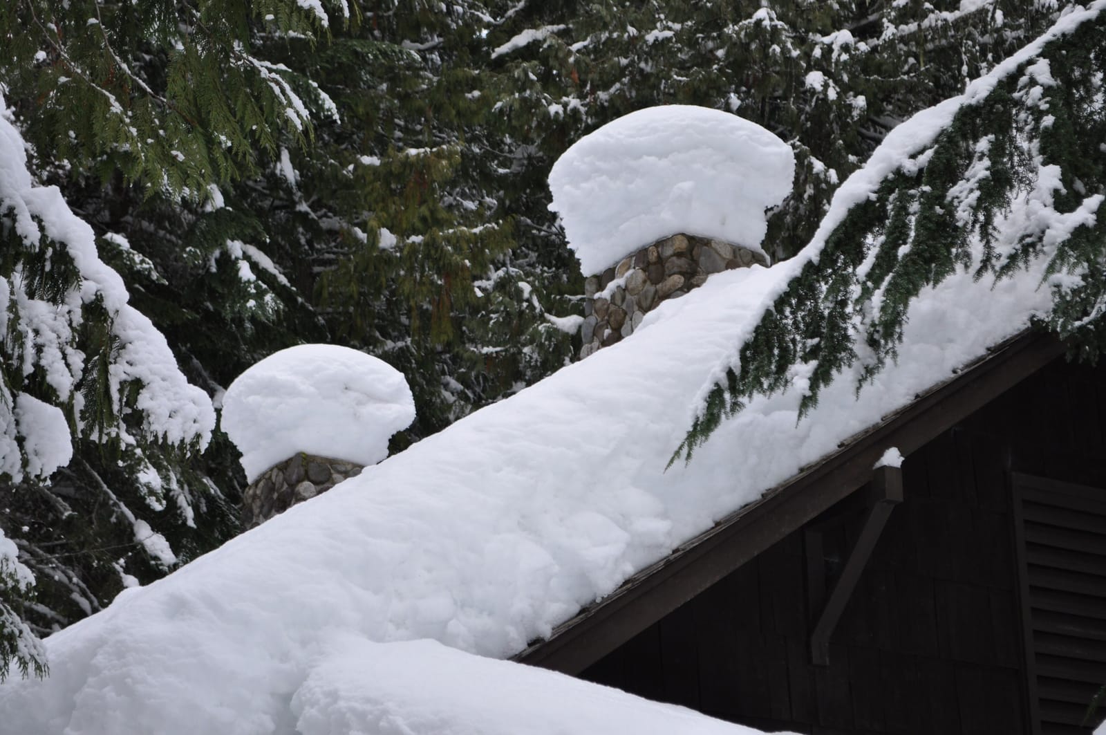Toiture de maison lourdement chargée de neige avec cheminées